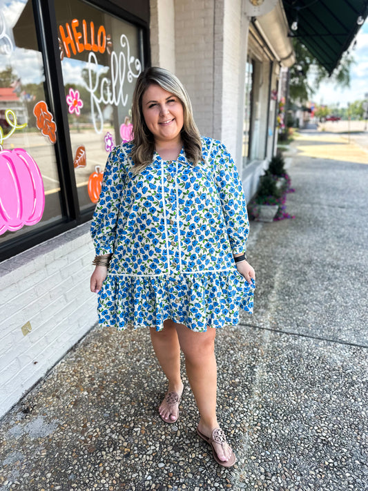 in a field of blue flowers dress